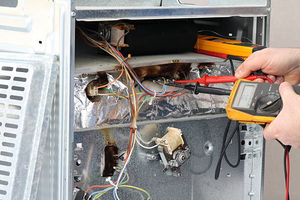 A person checks air conditioner wiring with a multimeter, focusing on appliance repair diagnostics.
