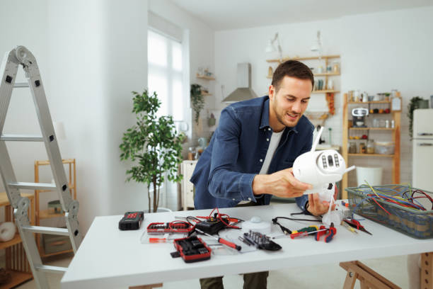A man is engaged in fixing electrical equipment in his home, surrounded by tools and parts. Same Day Appliance Repair service.